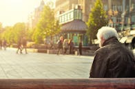 Man Sitting on Wooden Bench Wearing Black Leather Jacket