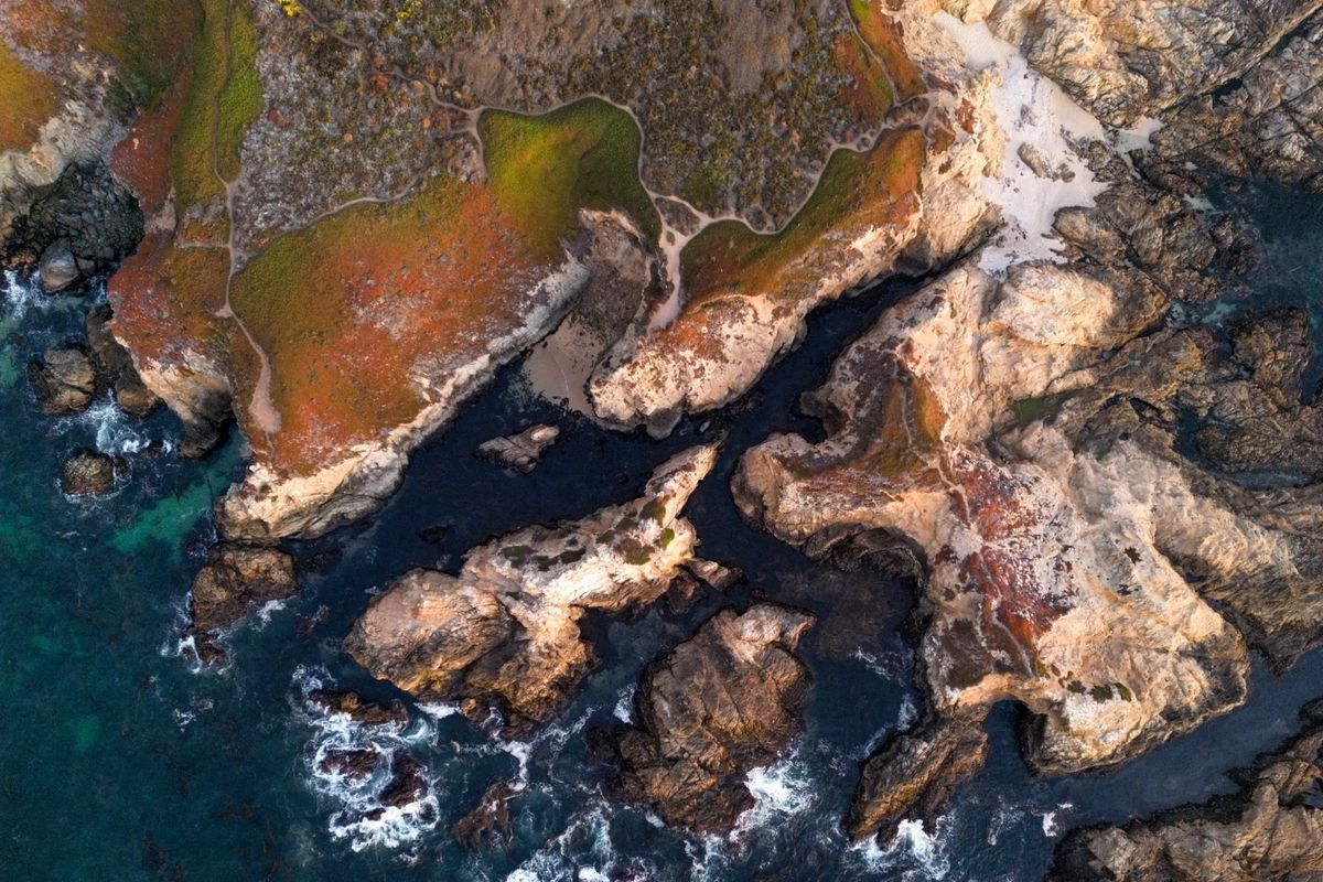 Aerial view of dramatic rocky ocean coastline with basalt formations and turquoise water — Tojinbo's columnar basalt sea cliffs in Fukui Prefecture