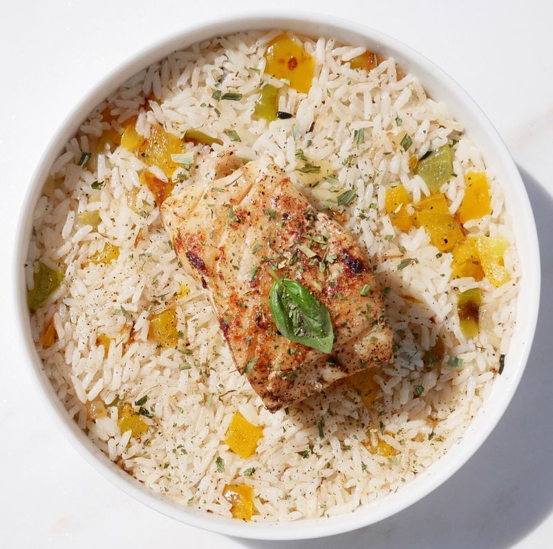 Seared white fish fillet over herbed rice with peppers — photo by Koema Photographies on Pexels