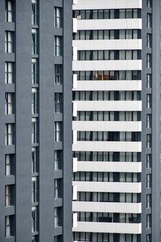 A detailed view of a modern high-rise apartment building with black and white facades.