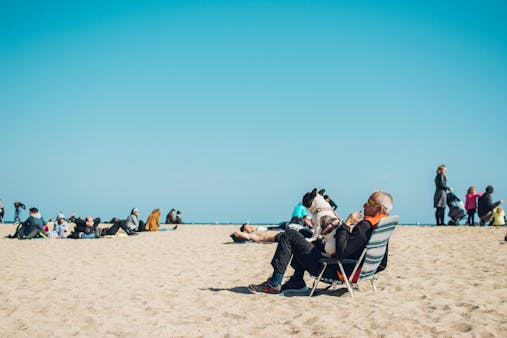 Elderly man with dog enjoying a sunny day at the beach in Barcelona, Spain.