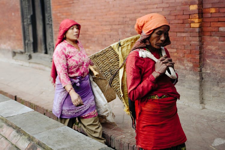 Women Walking On Street With Empty Baskets