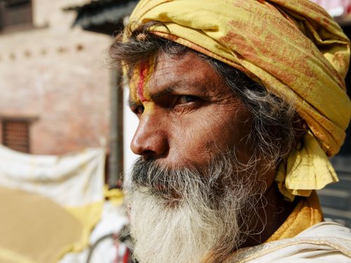Free Close-up portrait of an elderly man with a yellow head wrap and white beard in natural light. Stock Photo
