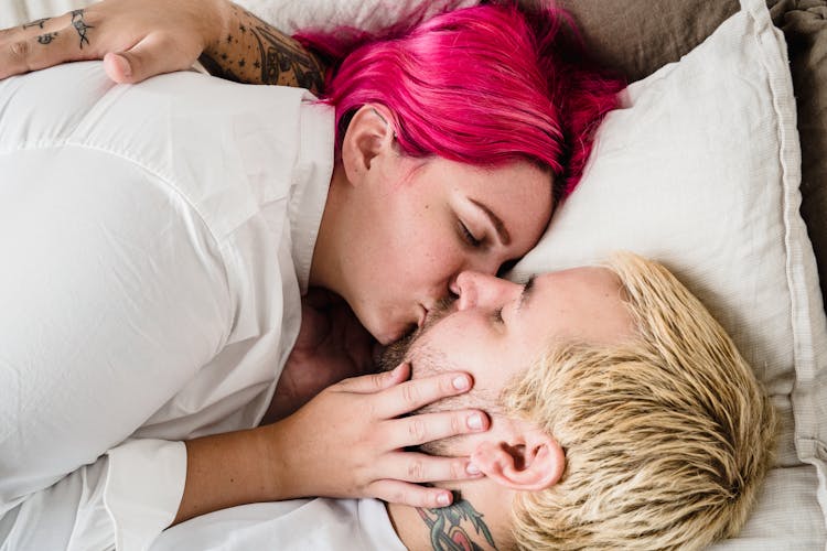 Woman And Man Kissing In Bed