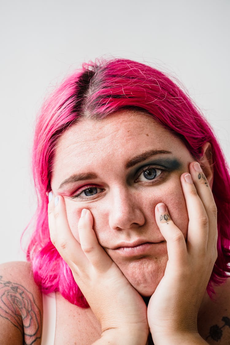 Unhappy Woman With Pink Hair And Makeup On White Background