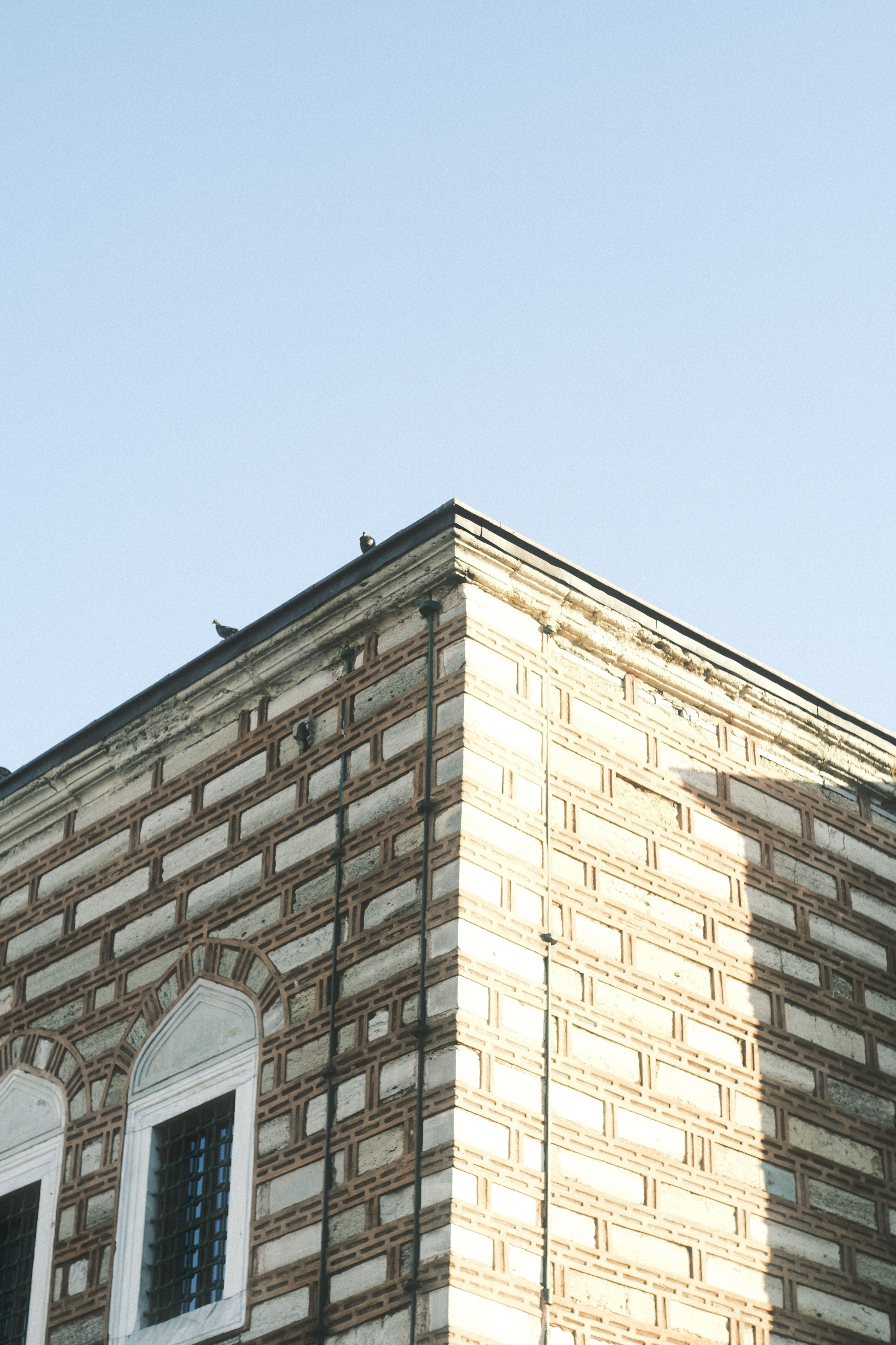 Cornice and roofline corner of a historic building showing a built-in gutter concealed in the trim