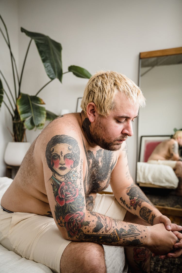 Shirtless Man In Tattoos Sitting At Home