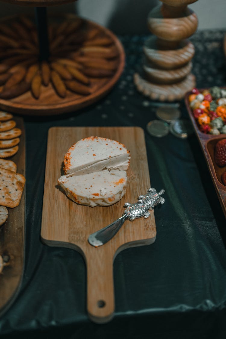 Decorative Knife Lying On Wooden Cutting Board With Piece Of Cheese