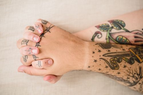 Free Two tattooed hands clasped together, symbolizing love and connection. Stock Photo