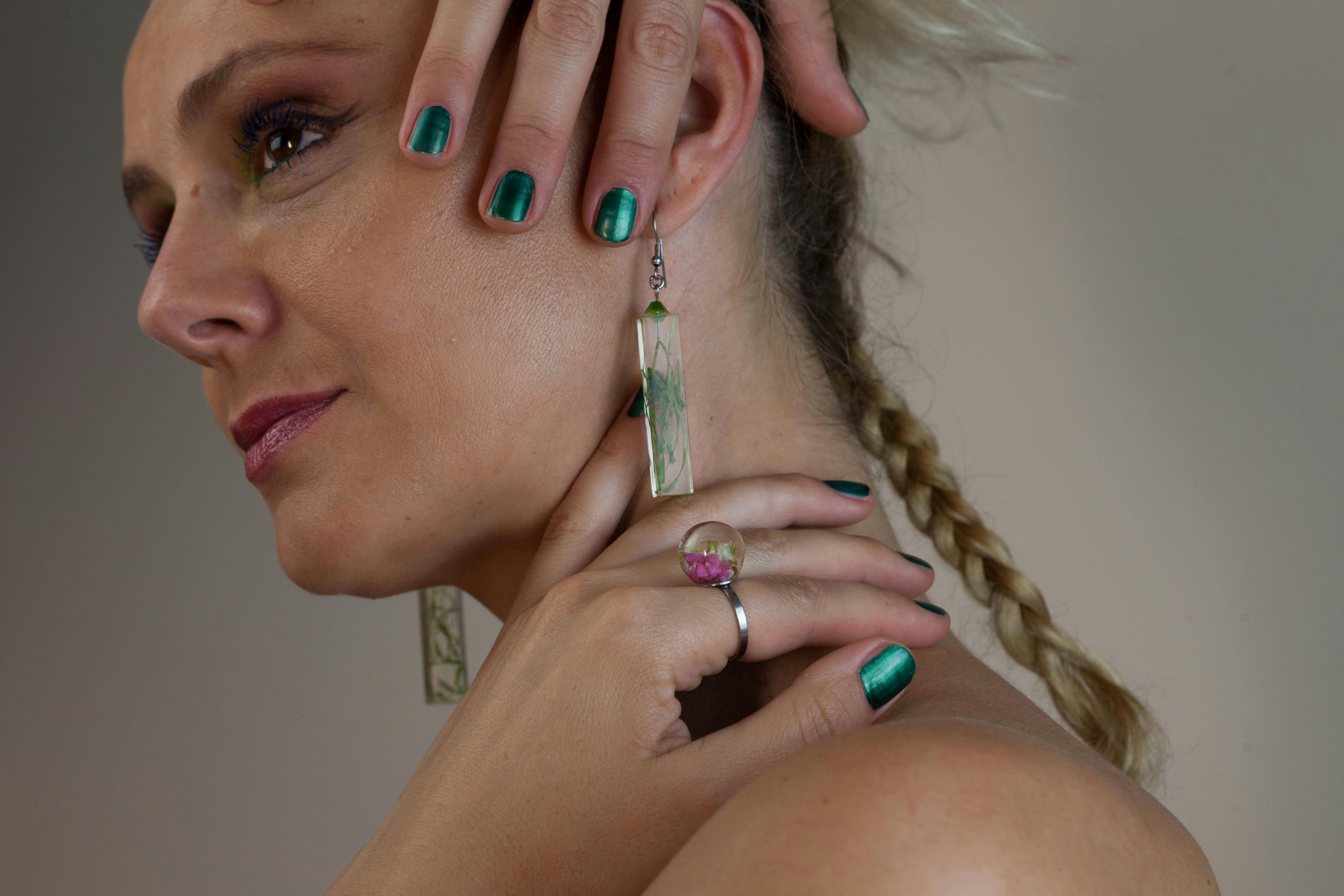 woman wearing earrings while holding her neck