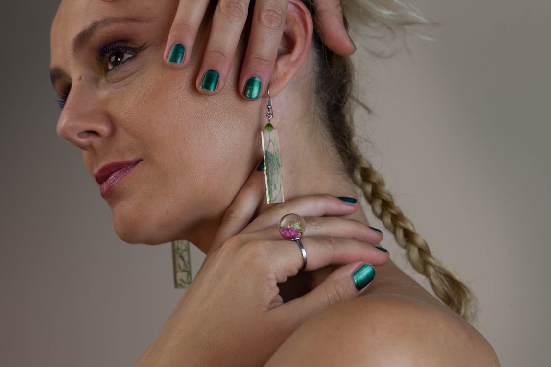 Woman Wearing Earrings While Holding Her Neck