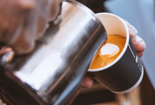 Close-up of latte art being poured into a coffee cup in Riyadh, Saudi Arabia, showcasing barista skills.