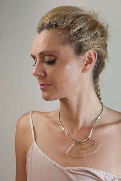 Woman in White Top and Gold-colored Necklace