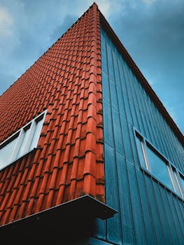Low-angle view of a modern building in Slootdorp, Netherlands, against a blue sky.