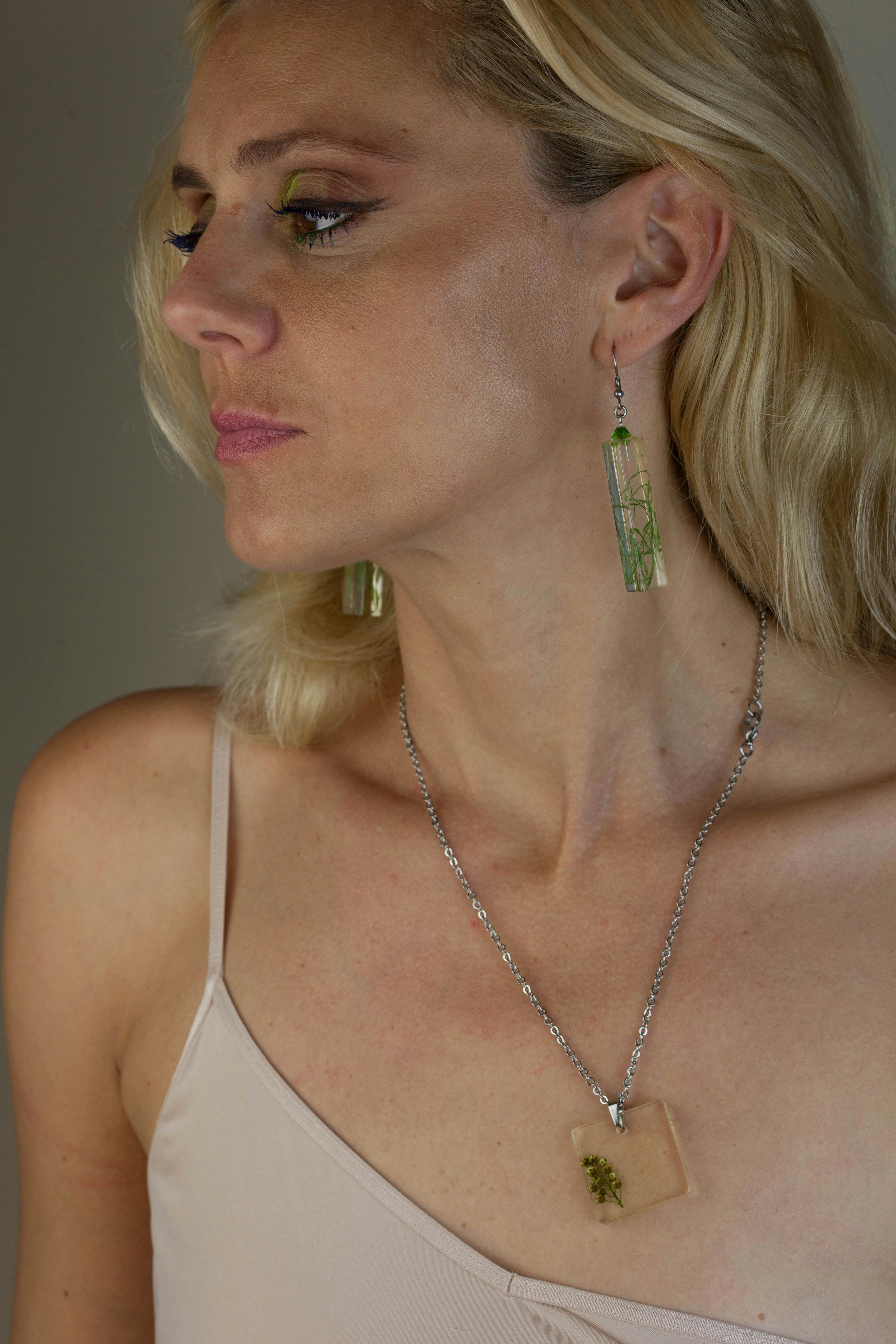 Gratis Wanita Mengenakan Kalung, Anting Anting Dan Atasan Tali Spaghetti Putih Foto Stok