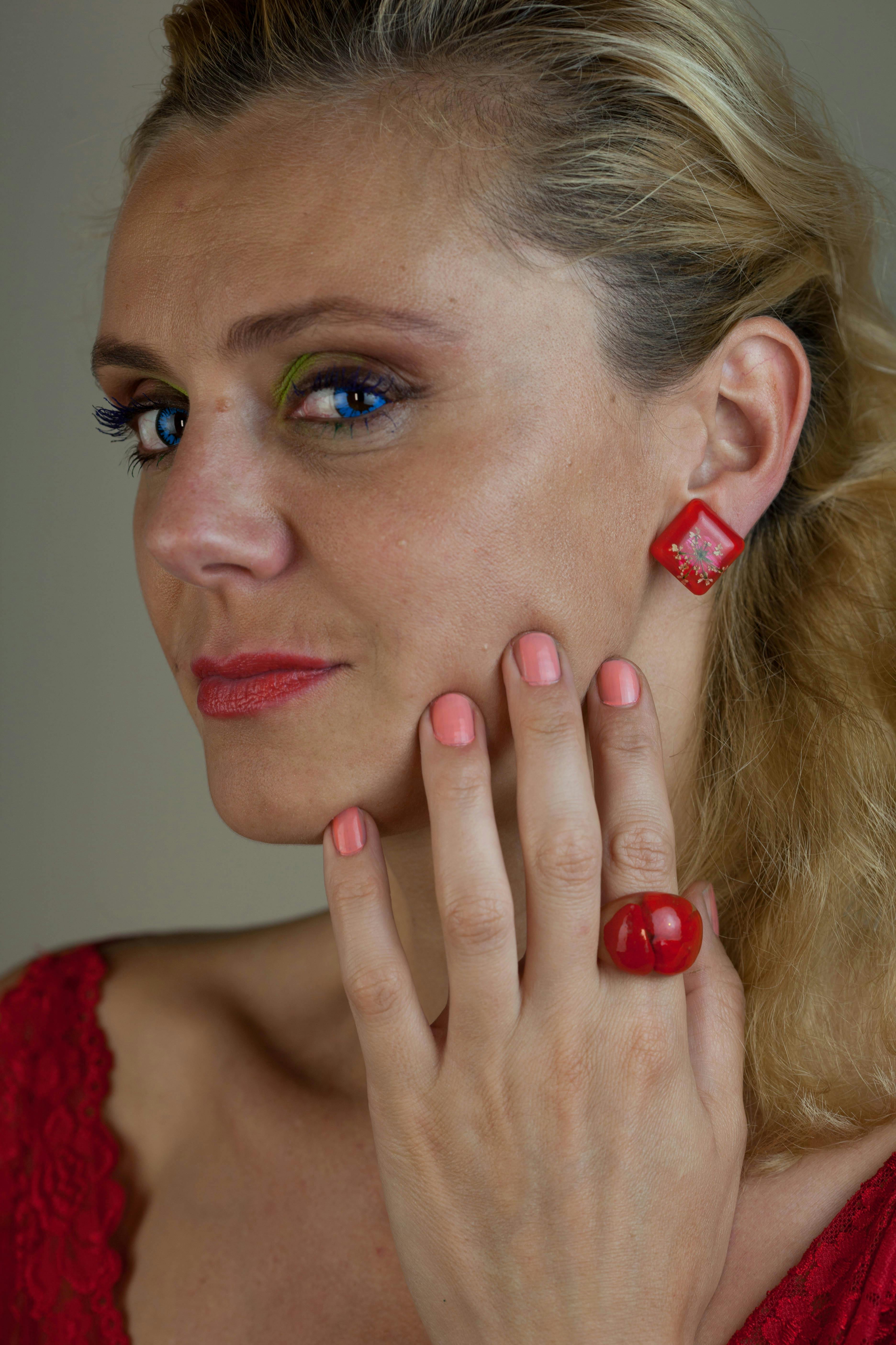 woman wearing red dress holding her face