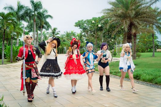 A group of cosplayers dressed as anime characters enjoying an outdoor festival.
