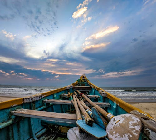 Blue and Beige Boat on Sand Near Ocean