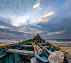 日出时，在沙滩上可以看到独木舟和充满活力的天空与海景