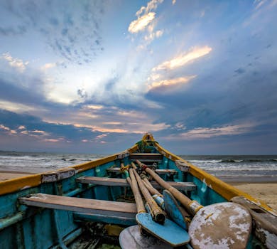 日出时，在沙滩上可以看到独木舟和充满活力的天空与海景