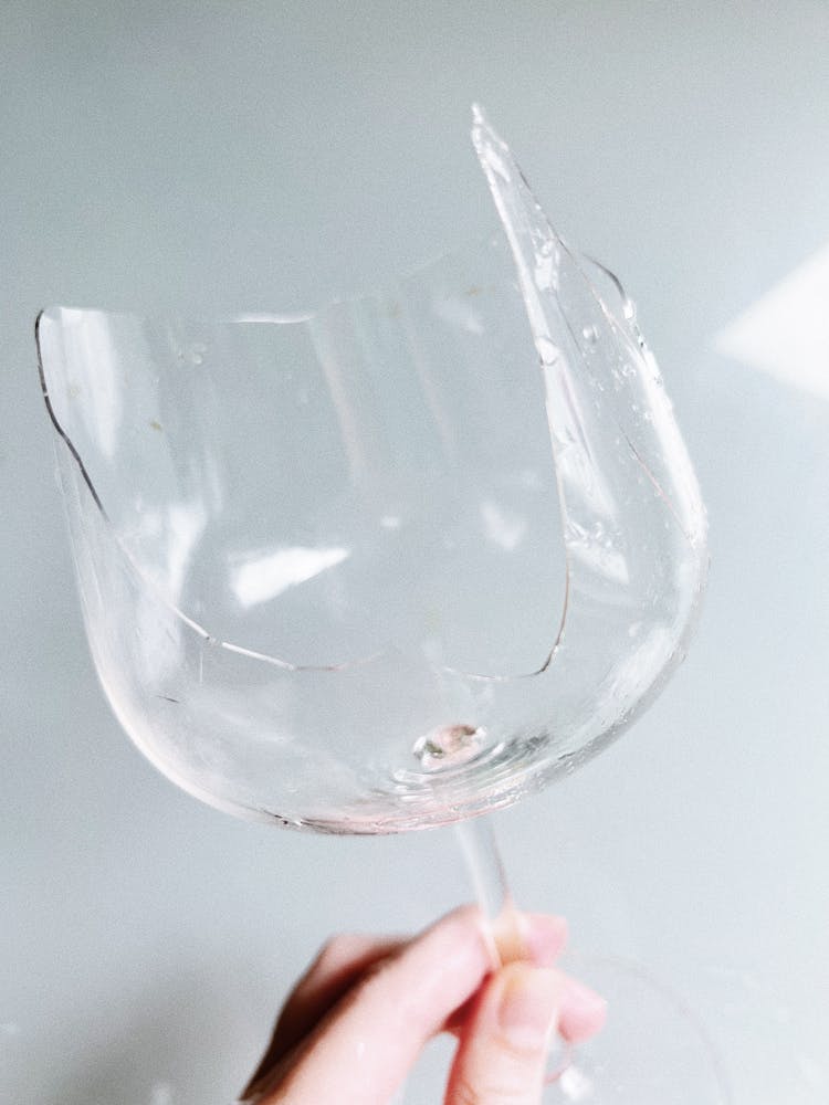 A Person Holding A Broken Wine Glass