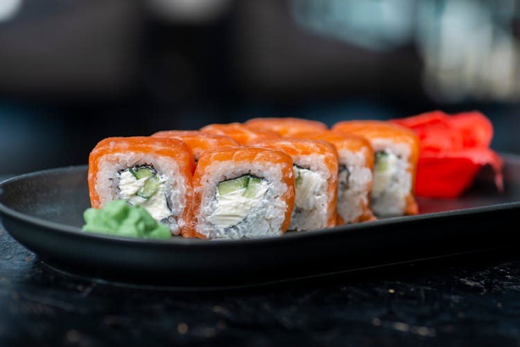 A Sushi Rolls On Black Ceramic Plate