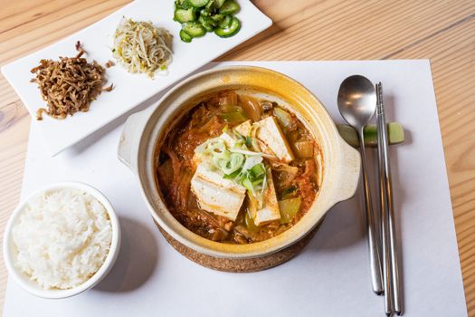 A vibrant, healthy vegan meal featuring tofu stew with rice and vegetables, perfect for food enthusiasts.