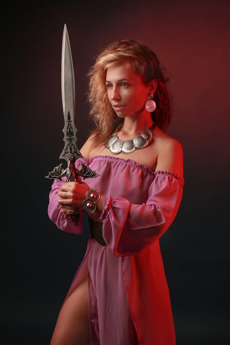 A Woman In Off Shoulder Dress Holding A Sword