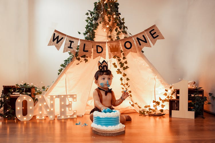 A Boy Sitting Beside His Birthday Cake