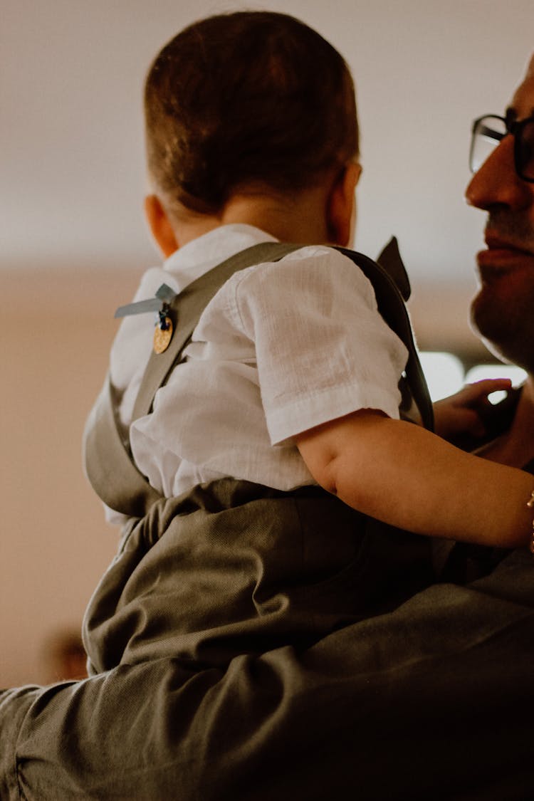 A Man Carrying A Baby Boy