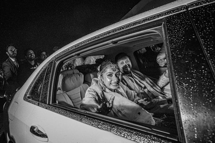 Smiling Couple Sitting In A Back Of A Car