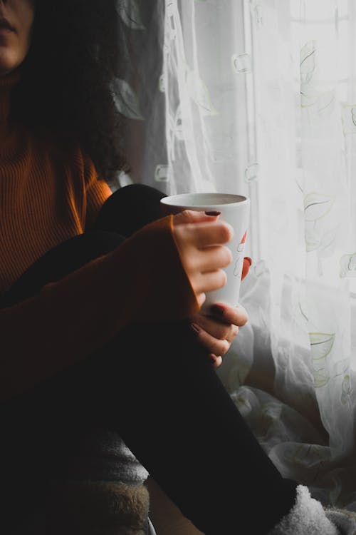 Close-Up Shot of a Person Holding a Hot Coffee Drink