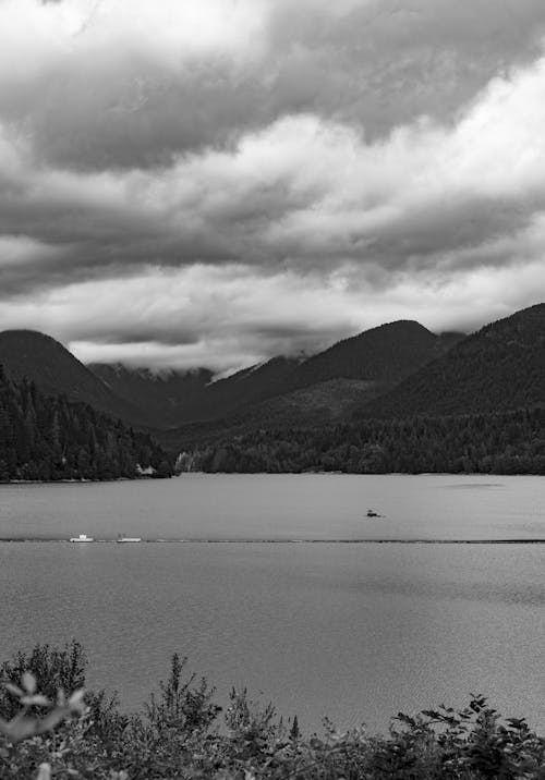 Grayscale Photo of a Lake Near Mountains