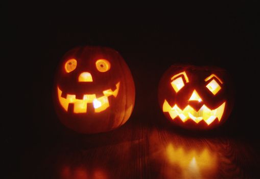 Two glowing jack-o'-lanterns add spooky charm to a Halloween night scene.