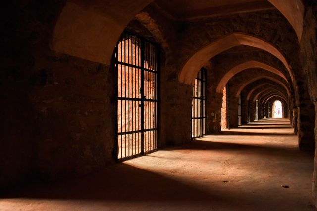 Dramatic light in an ancient stone corridor with arches — photo by Tanuj Matta on Pexels