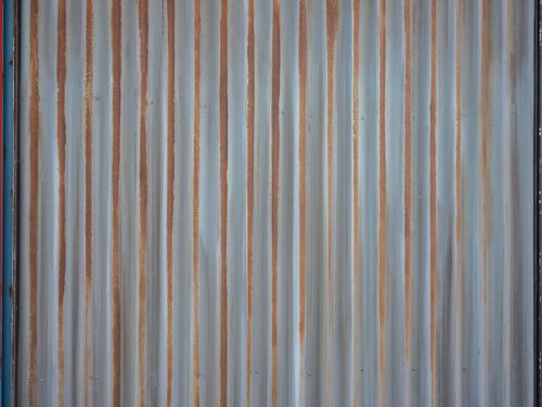 Free Close-up of a rusted, corrugated metal wall with a grungy texture. Stock Photo