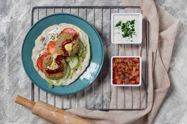 Top view of vegetarian falafel on a blue plate with dips, perfect for food photography.