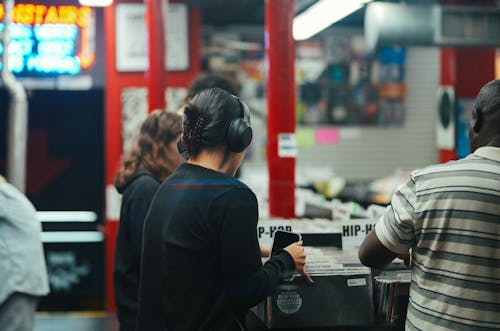 Woman in Black Long Sleeve Shirt Wearing Headphones
