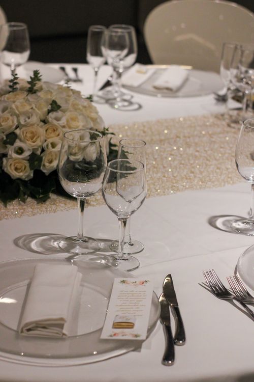 Free A beautifully arranged wedding table with white roses and sparkling decor creating an elegant ambiance. Stock Photo