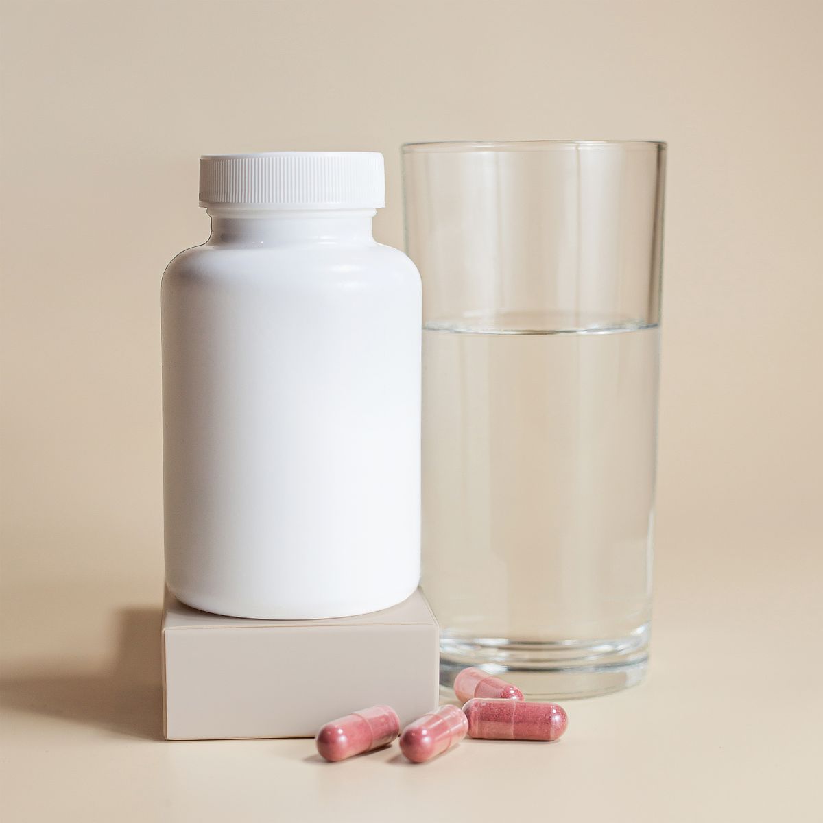 A Verdal kit bottle, capsules and a glass of water — photo by Supplements On Demand on Pexels