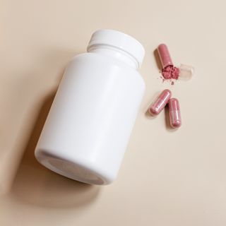 A white treatment bottle beside loose capsules — photo by Supplements On Demand on Pexels