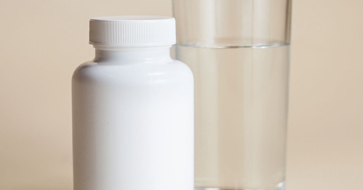 A plain white supplement bottle on a clean pale surface