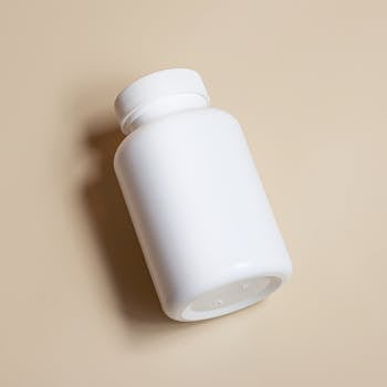 White supplement bottle on beige background, perfect for product packaging concepts.