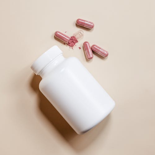 Pills Lying next to White Bottle