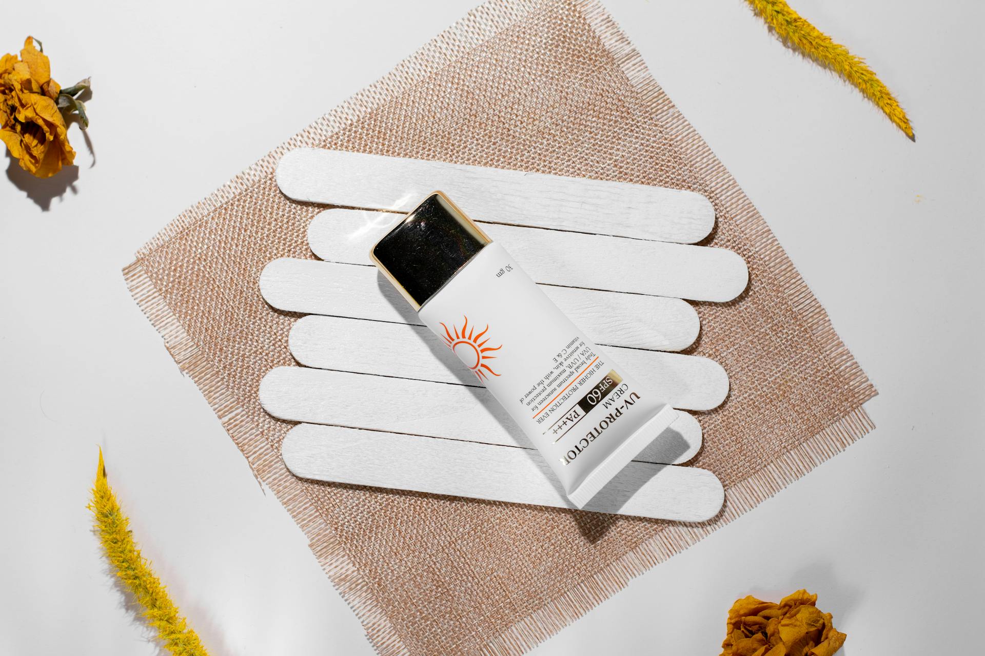 Minimalist flat lay of sunscreen SPF 60 with natural elements, enhancing beauty care theme.