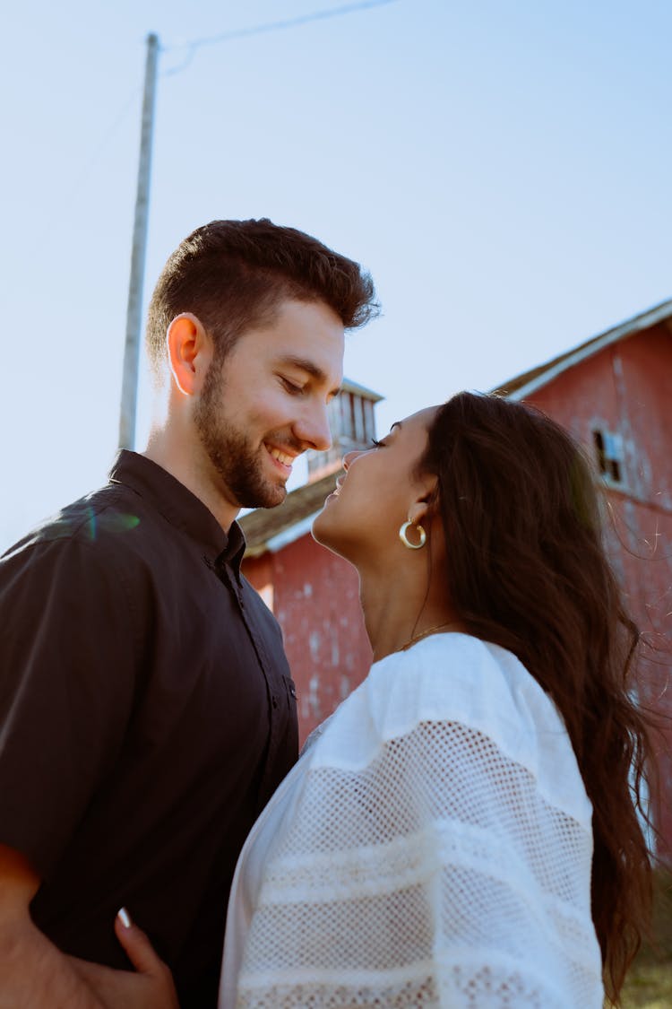 Young Couple Standing Face To Face And Smiling 