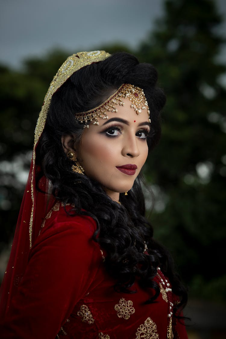 A Woman Wearing Red And Gold Veil 