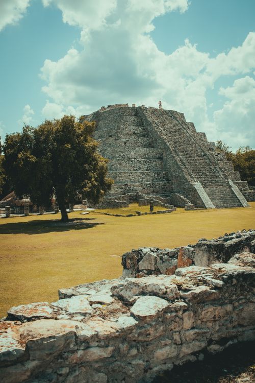 Free Stone pyramid surrounded by greenery under a bright summer sky in Mexico. Stock Photo