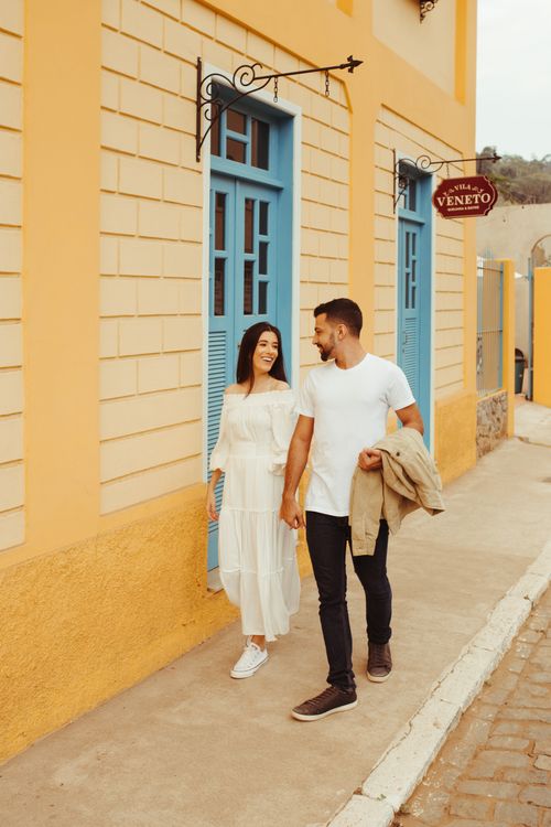 Free A couple enjoys a romantic walk outside a colorful building in Santa Teresa, Brazil. Stock Photo