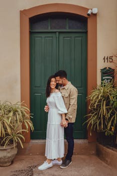 A couple shares a romantic moment outside a green door in Santa Teresa.